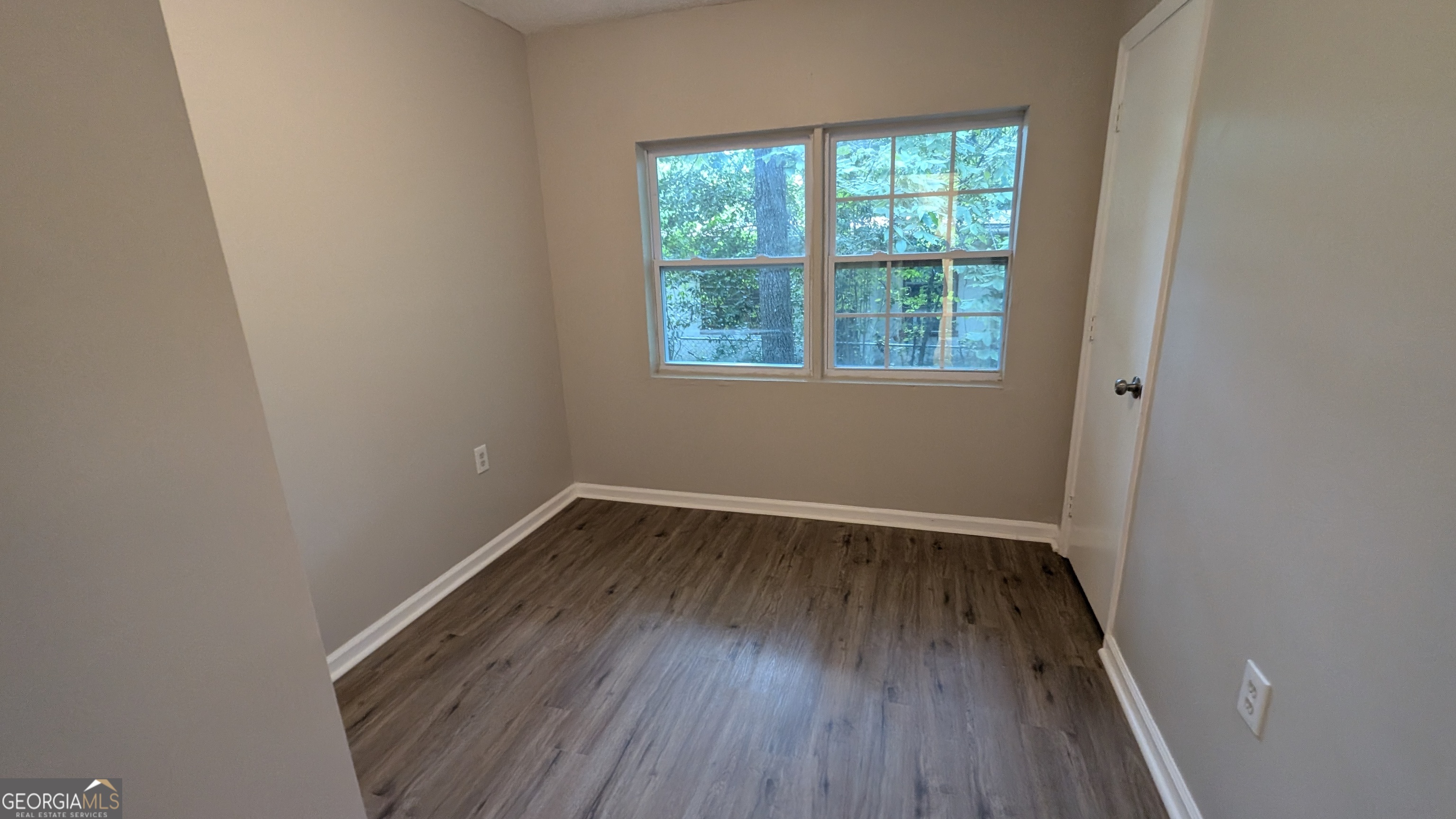 402 Johns Road Warner Robins, GA 31093 - Photo 7 of 8 a view of an empty room with wooden floor and a window