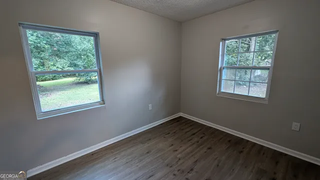 a view of a room with wooden floor and windows