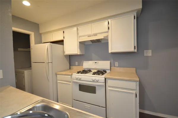 a kitchen with a stove a refrigerator and a sink