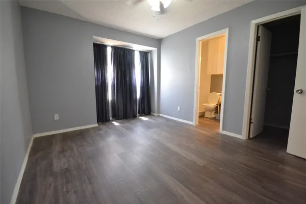 an empty room with wooden floor and closet area