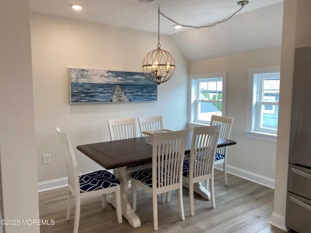 a view of a dining room with furniture wooden floor and chandelier