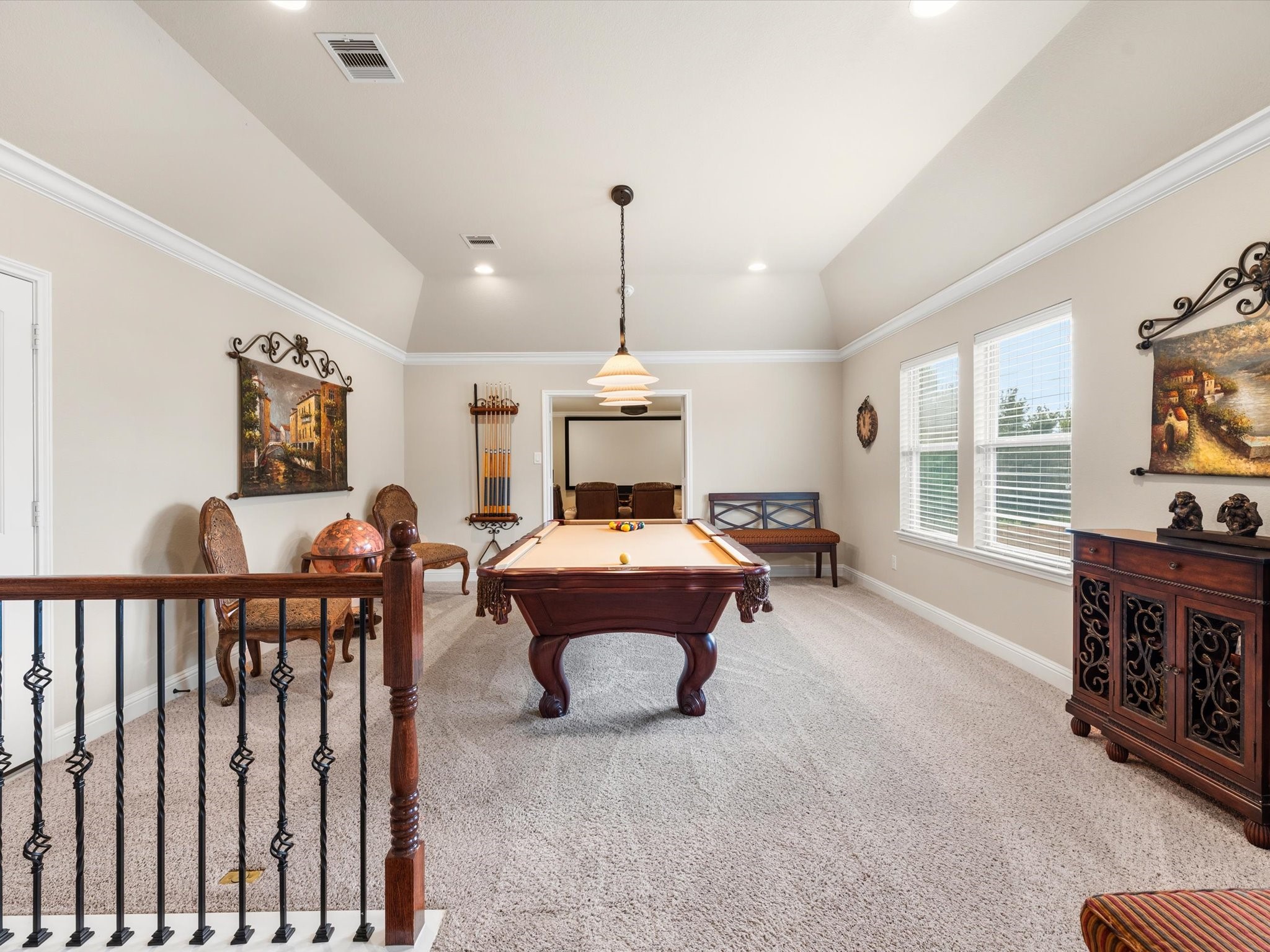 3907 Randle Ridge Court Fulshear, TX 77441 - Photo 28 of 46 This spacious game room features a pool table, plush carpet, and elegant decor with ample natural light from large windows. Perfect for entertainment and relaxation.