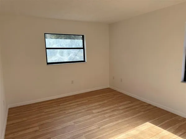 a view of a small space with wooden floor and window