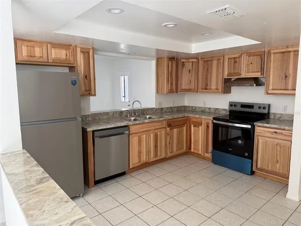 a kitchen with stainless steel appliances granite countertop a stove a sink and a refrigerator