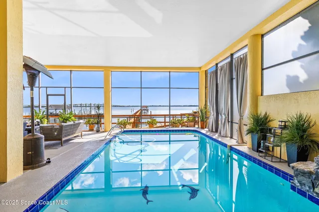 a view of a living room and floor to ceiling window kitchen