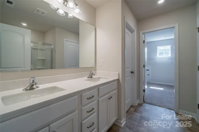 a bathroom with a double vanity sink and mirror with shower