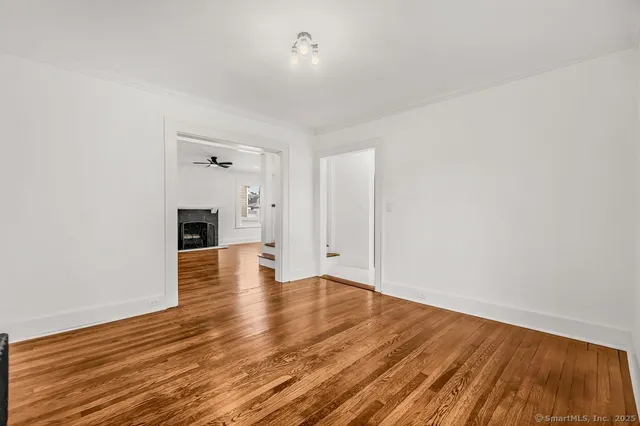 a view of empty room with wooden floor and fireplace