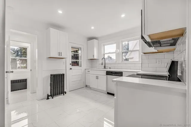 a kitchen with white cabinets and appliances