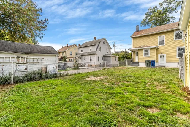 a view of a house with a big yard and large tree