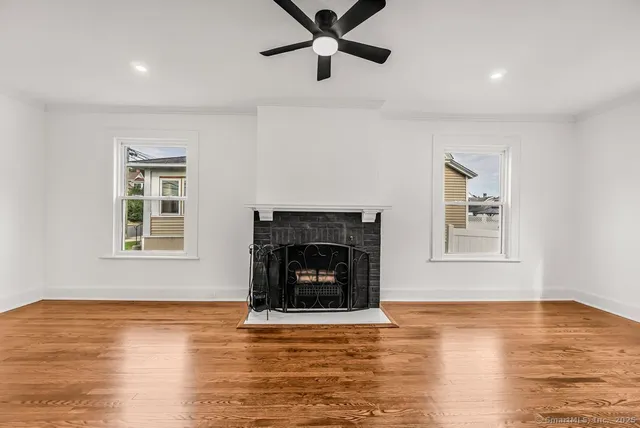 a living room with a fireplace and wooden floor