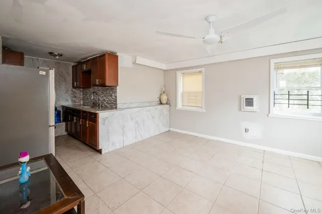 a living room with stainless steel appliances kitchen island granite countertop a refrigerator and a stove top oven