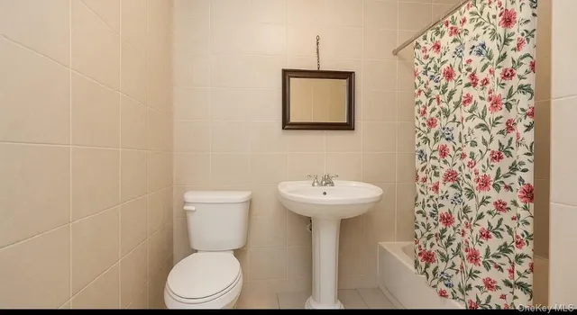 a bathroom with a toilet sink and shower curtain