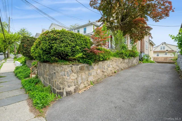 a view of a street with potted plants and a fountain