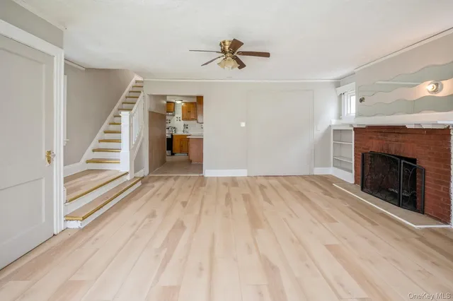 a view of a livingroom with wooden floor and a ceiling fan