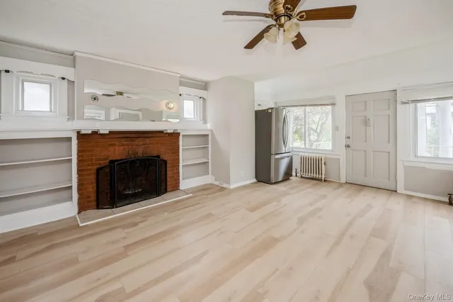 a view of empty room with a fireplace and window