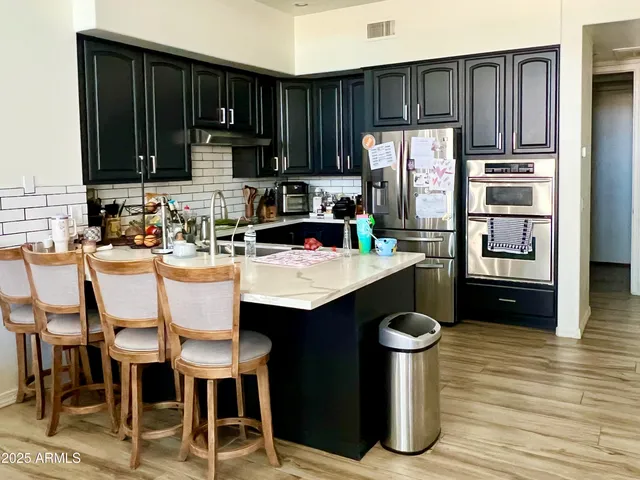 a kitchen with a sink refrigerator and cabinets