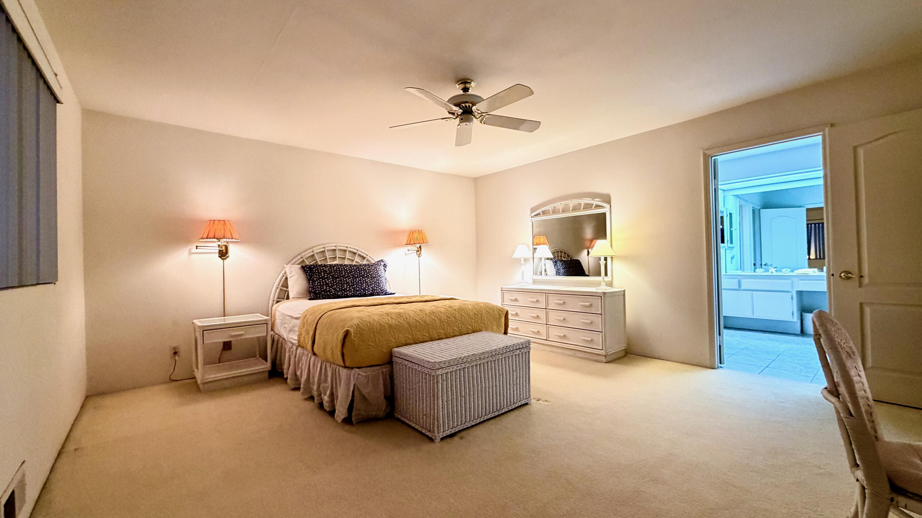 59 Oak Tree Drive Rancho Mirage, CA 92270 - Photo 17 of 22 a bedroom with a bed and a chandelier