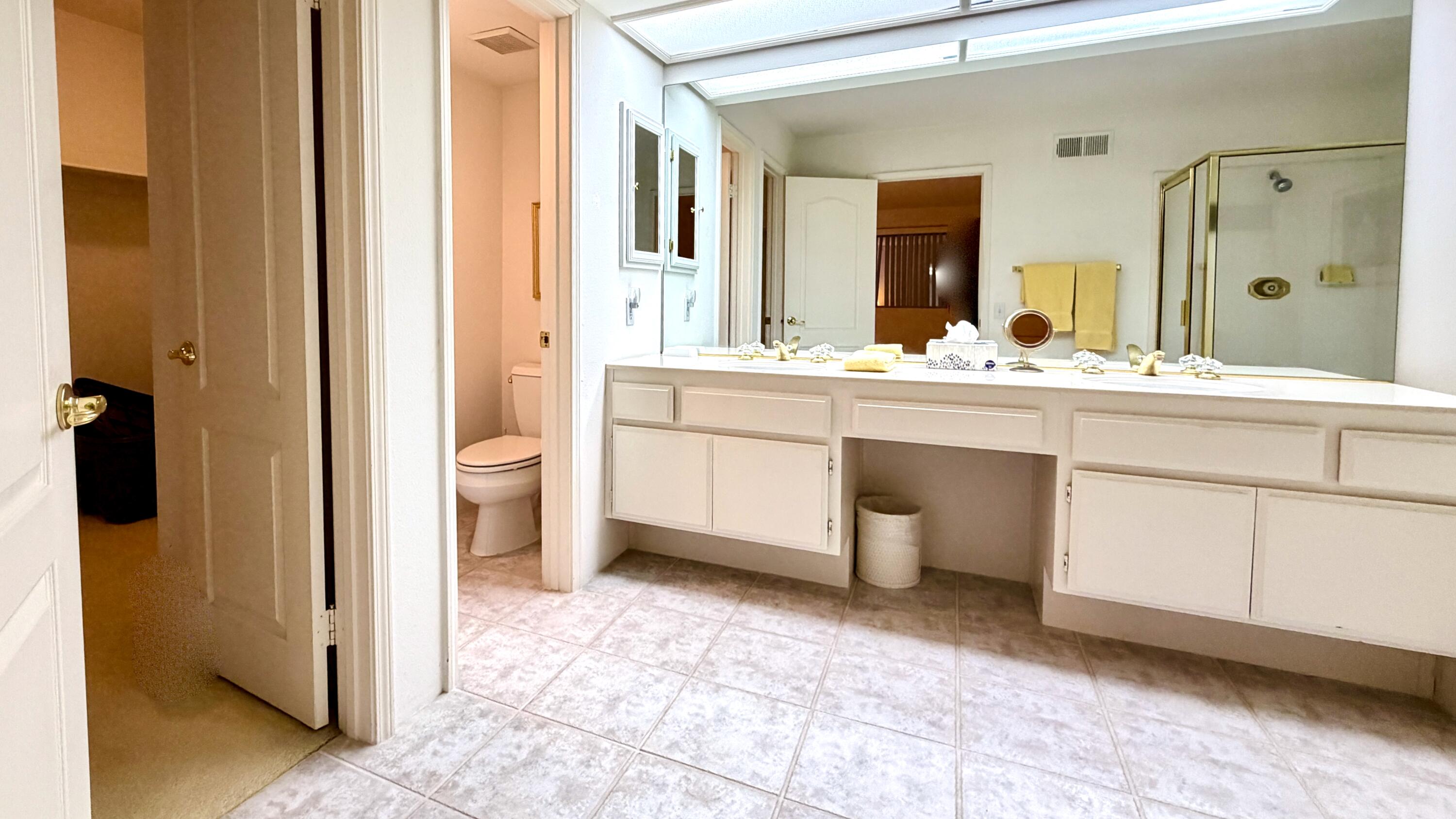 59 Oak Tree Drive Rancho Mirage, CA 92270 - Photo 18 of 22 a spacious bathroom with a sink and a mirror