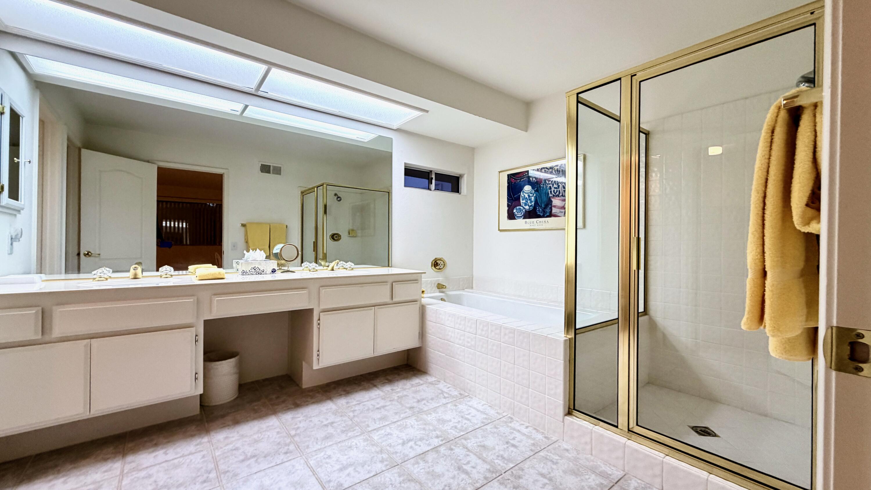59 Oak Tree Drive Rancho Mirage, CA 92270 - Photo 19 of 22 a spacious bathroom with a double vanity sink mirror and a bath tub