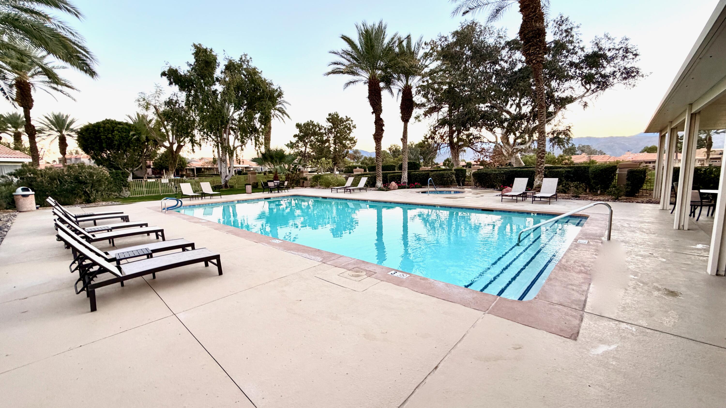 59 Oak Tree Drive Rancho Mirage, CA 92270 - Photo 21 of 22 a view of a swimming pool with a lounge chair