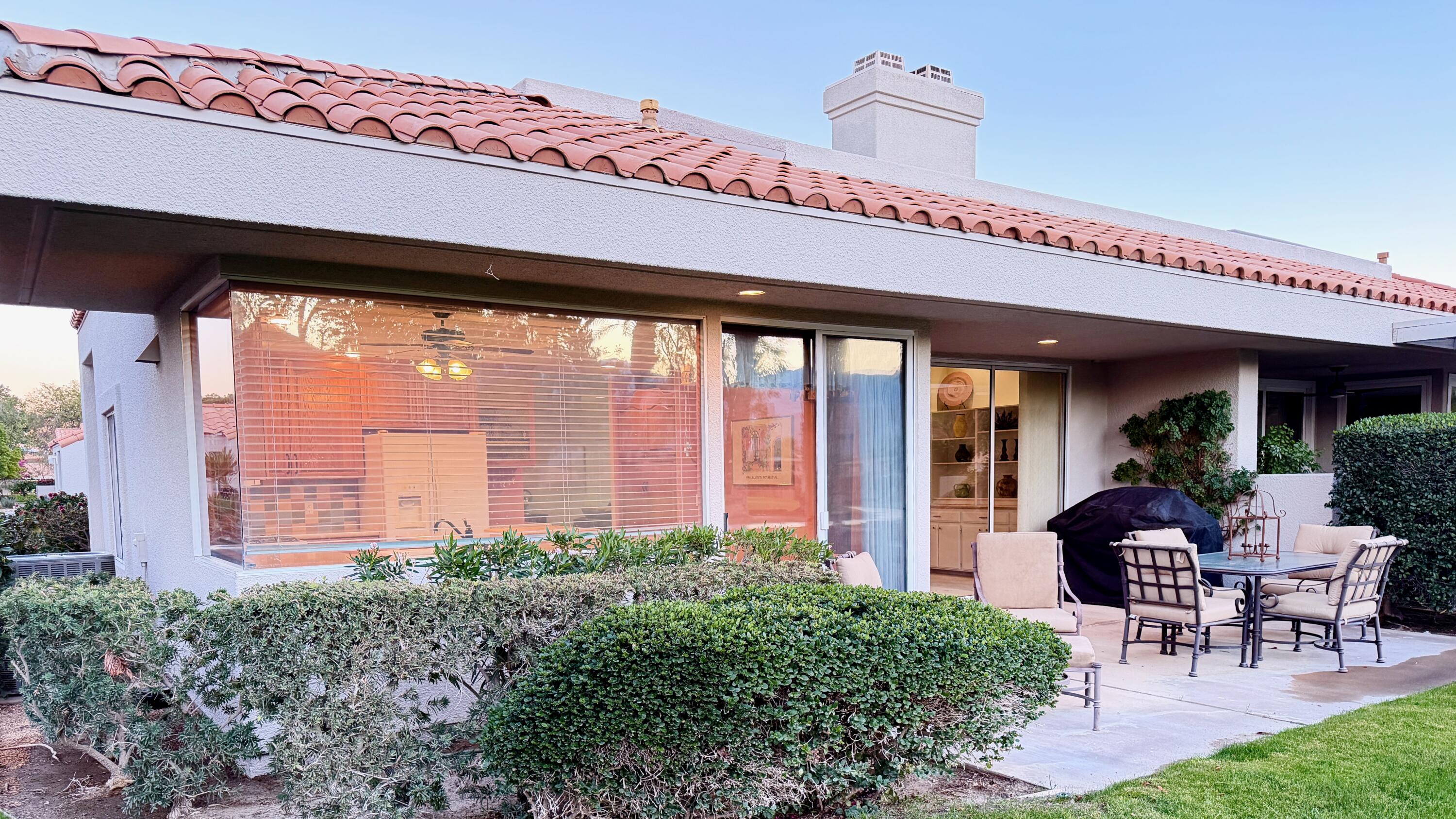59 Oak Tree Drive Rancho Mirage, CA 92270 - Photo 3 of 22 a view of a patio with a table and chairs under an umbrella