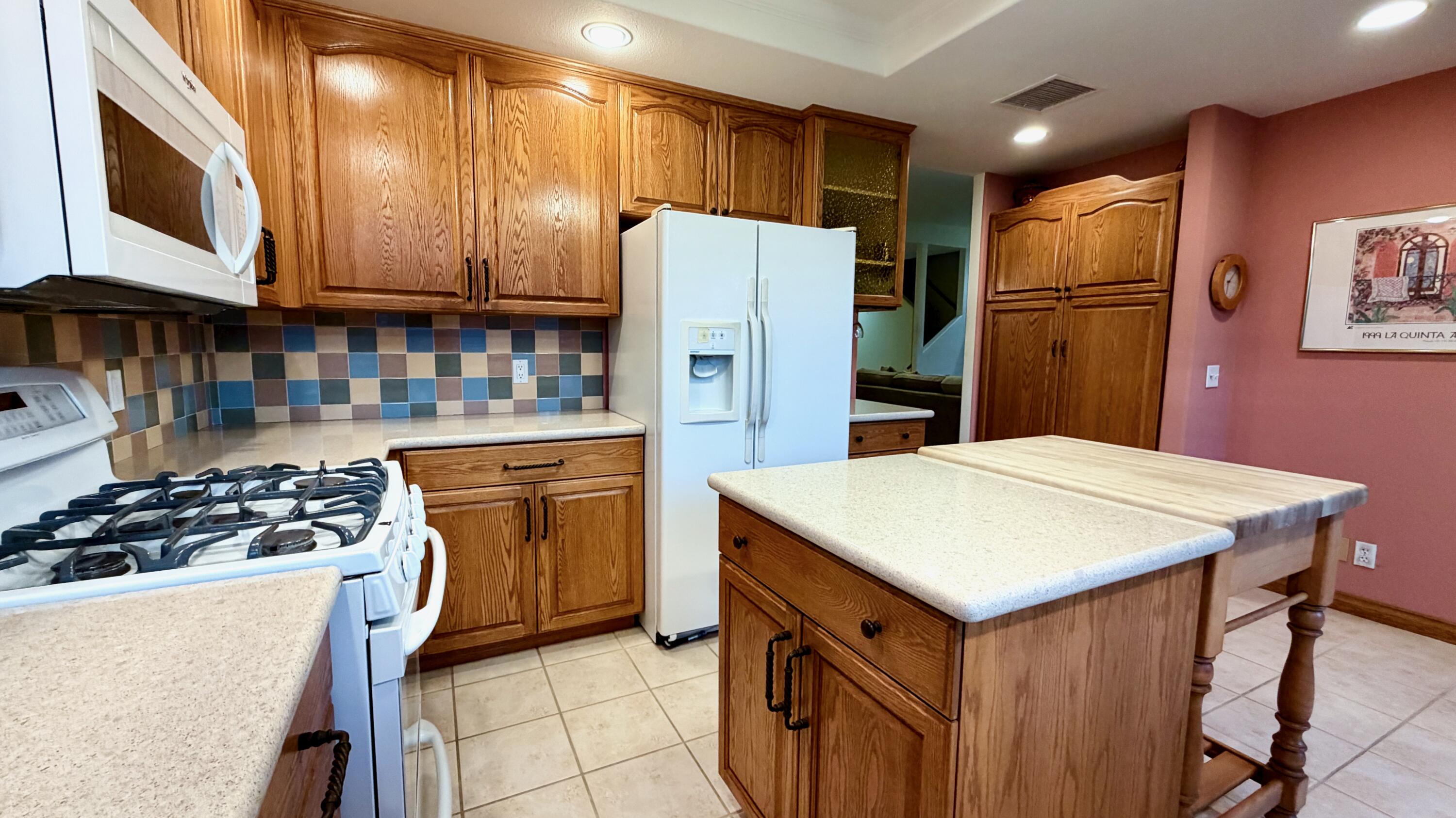 59 Oak Tree Drive Rancho Mirage, CA 92270 - Photo 6 of 22 a kitchen with stainless steel appliances a refrigerator sink and cabinets