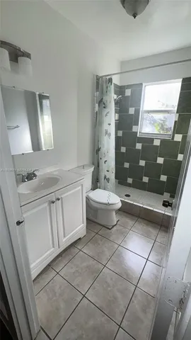 a bathroom with a double vanity sink toilet and shower