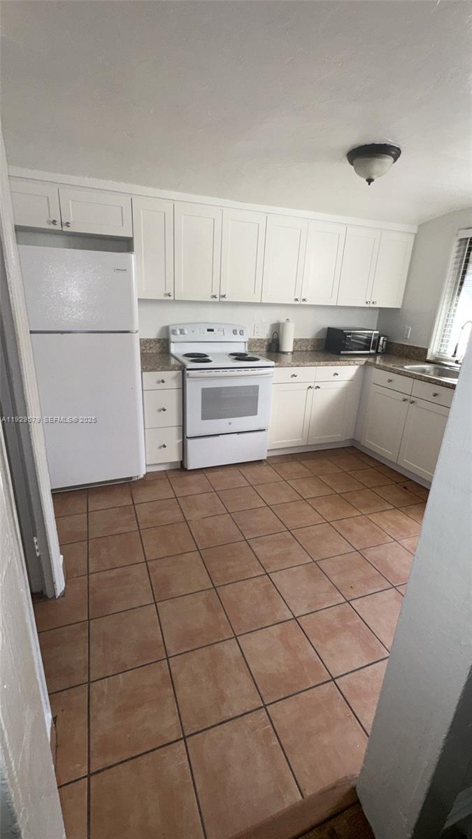 2430 Southwest 25th Terrace, Unit A Miami, FL 33133 - Photo 13 of 19 a kitchen with cabinets and appliances