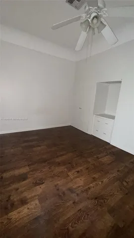 en empty room with an entryway and fan