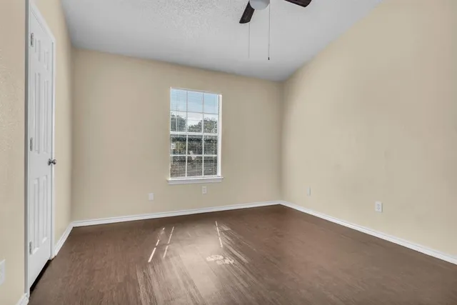 a view of a hallway with wooden floor windows and a kitchen