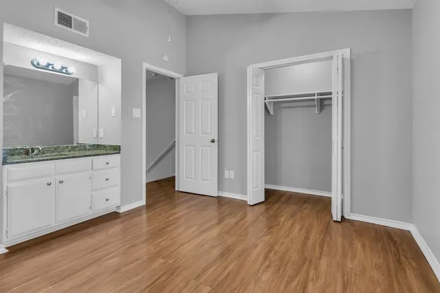 an empty room with wooden floor and cabinet