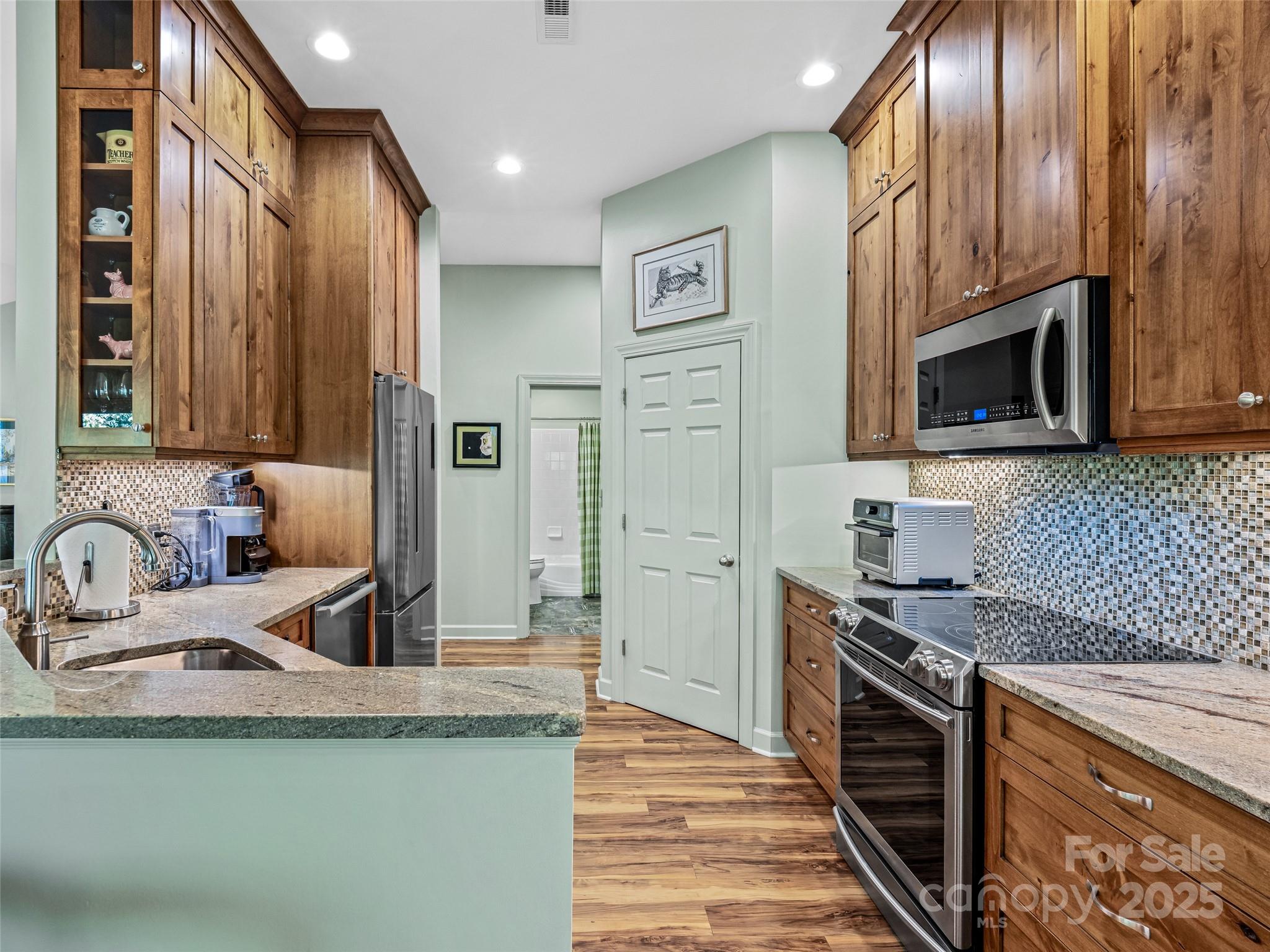 73 Ridgetop Circle, Unit 303 Brevard, NC 28712 - Photo 13 of 28 a kitchen with granite countertop a sink stainless steel appliances and cabinets