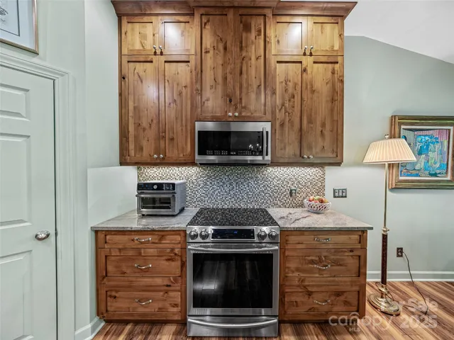 a kitchen with granite countertop a stove and a microwave