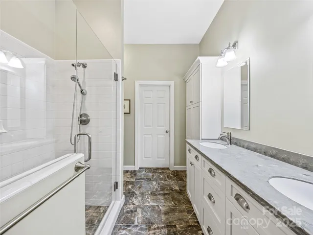 a bathroom with a granite countertop tub sink and mirror