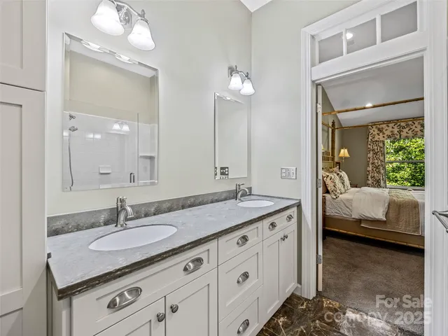 a en suite bathroom with a granite countertop sink and a mirror