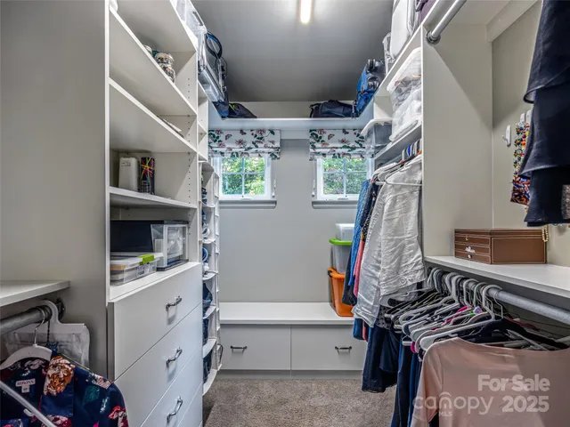 a view of walk in closet with clothes and shoes