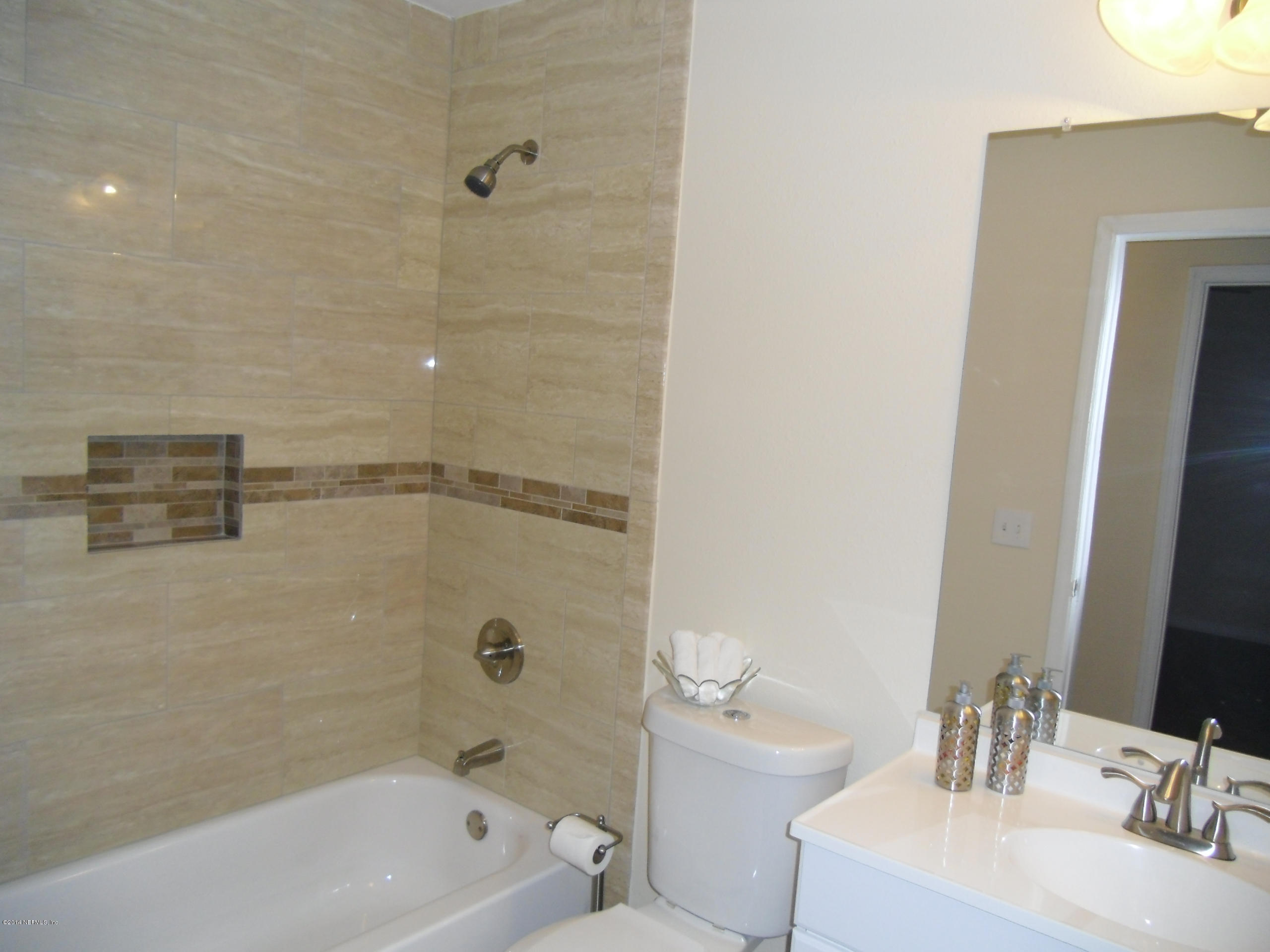 4221 Spring Park Road Jacksonville, FL 32207 - Photo 36 of 56 a bathroom with a bathtub a sink a toilet and a mirror