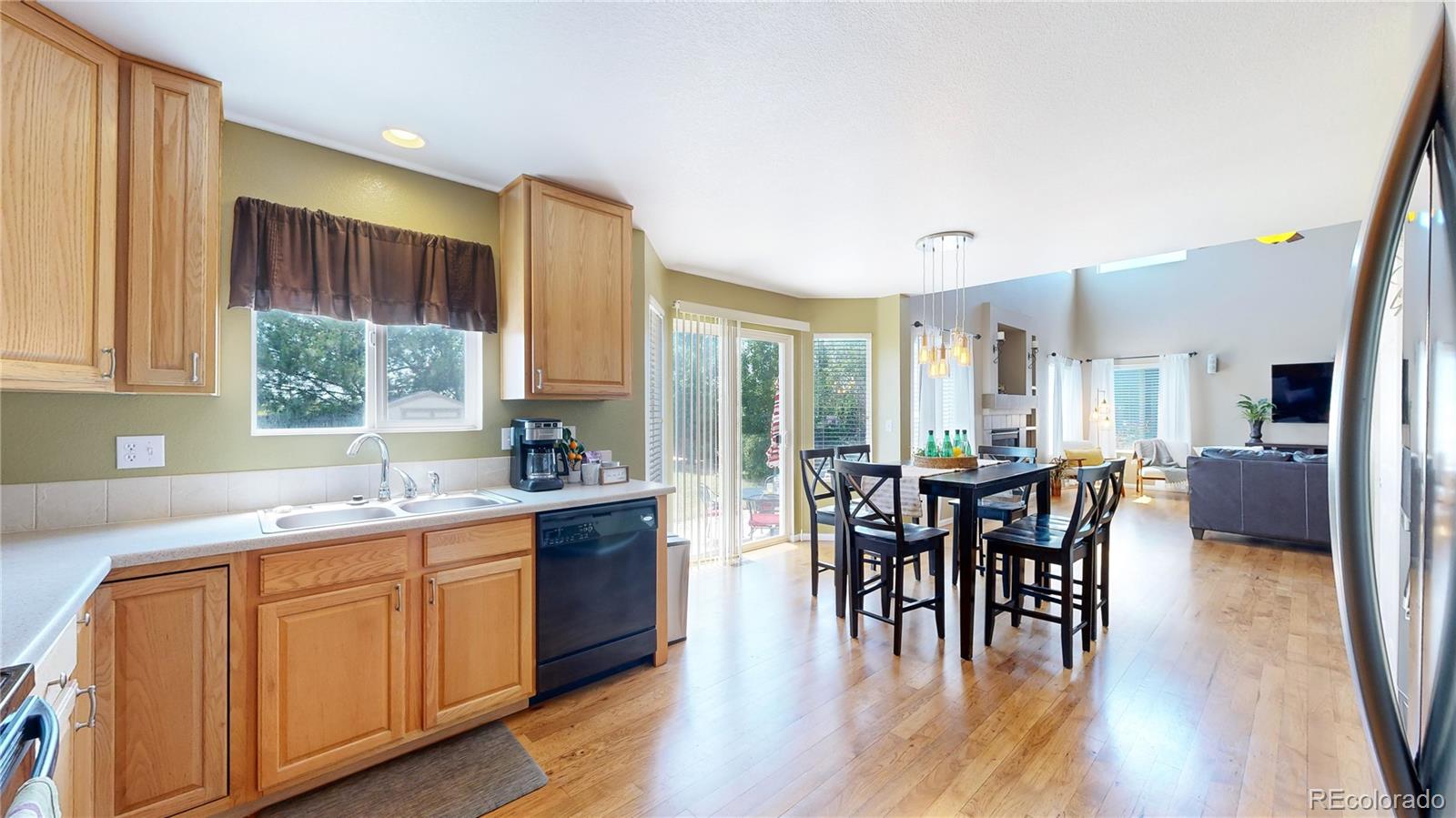 5759 Canyon Circle Longmont, CO 80504 - Photo 9 of 37 a kitchen with stainless steel appliances granite countertop sink stove and wooden cabinets