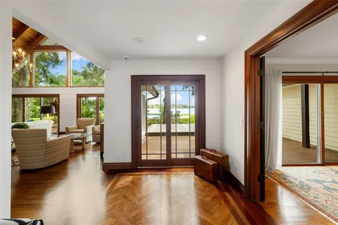 a living room with furniture a flat screen tv and a floor to ceiling window