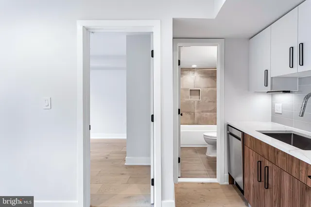 a view of a kitchen from the hallway with closet and a large window