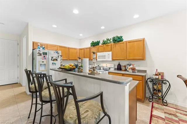 a kitchen with stainless steel appliances a table and chairs in it