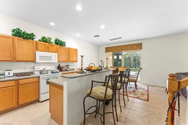 a kitchen with a table chairs microwave and cabinets