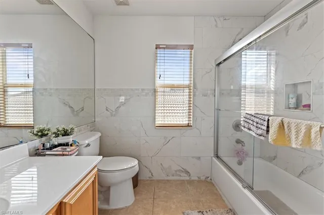 a bathroom with a granite countertop sink and a bathtub