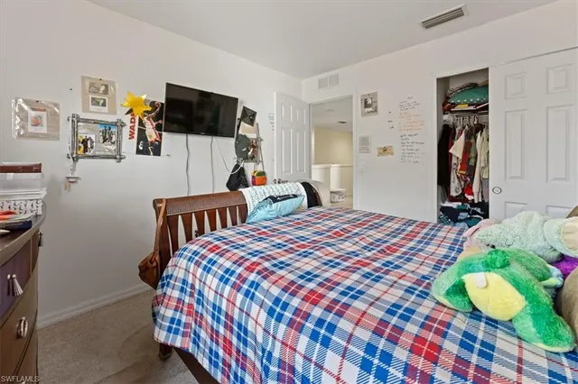 a bedroom with bed and a flat screen tv