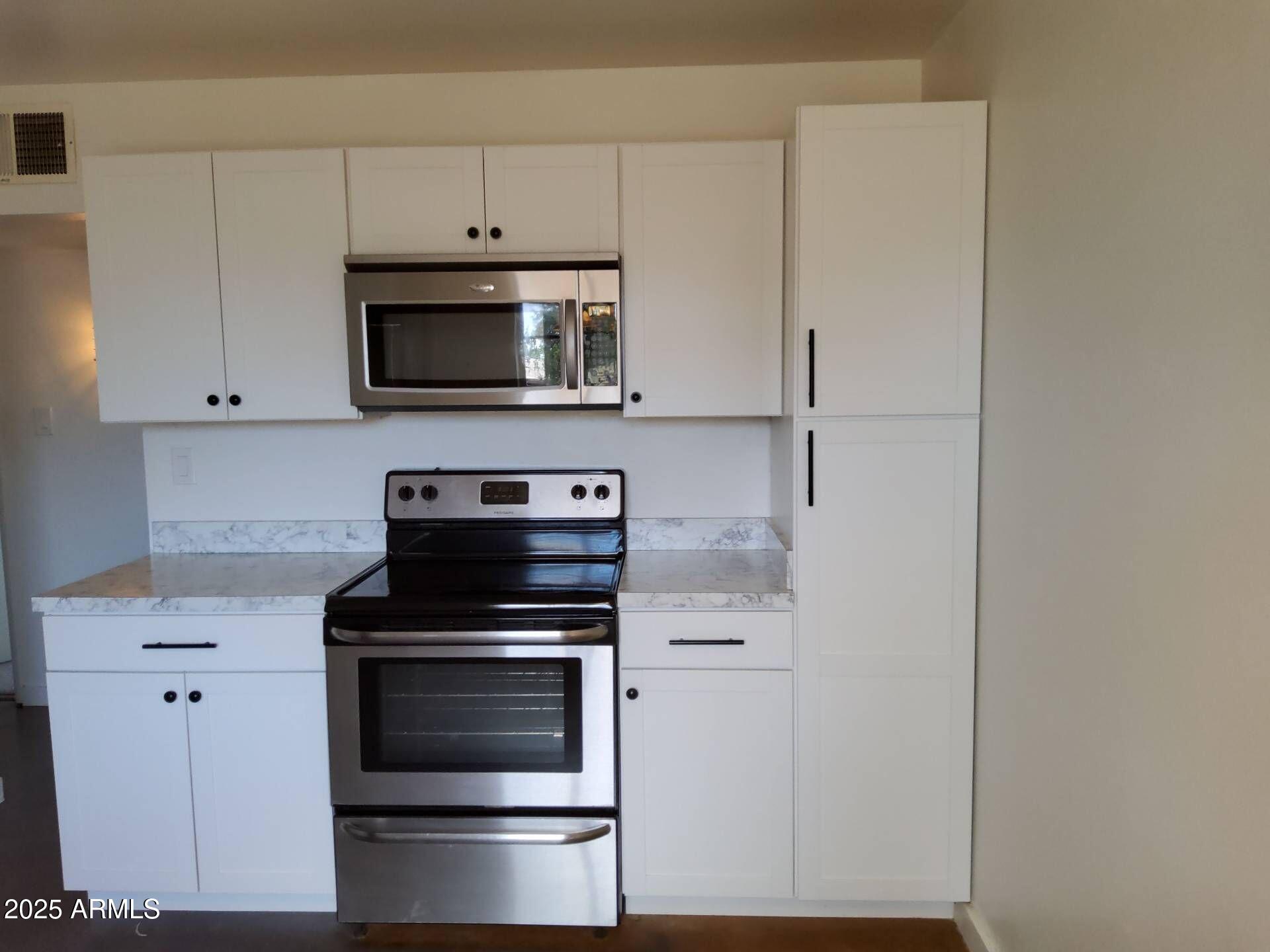915 West 17th Place Tempe, AZ 85281 - Photo 3 of 13 a kitchen with cabinets and stainless steel appliances