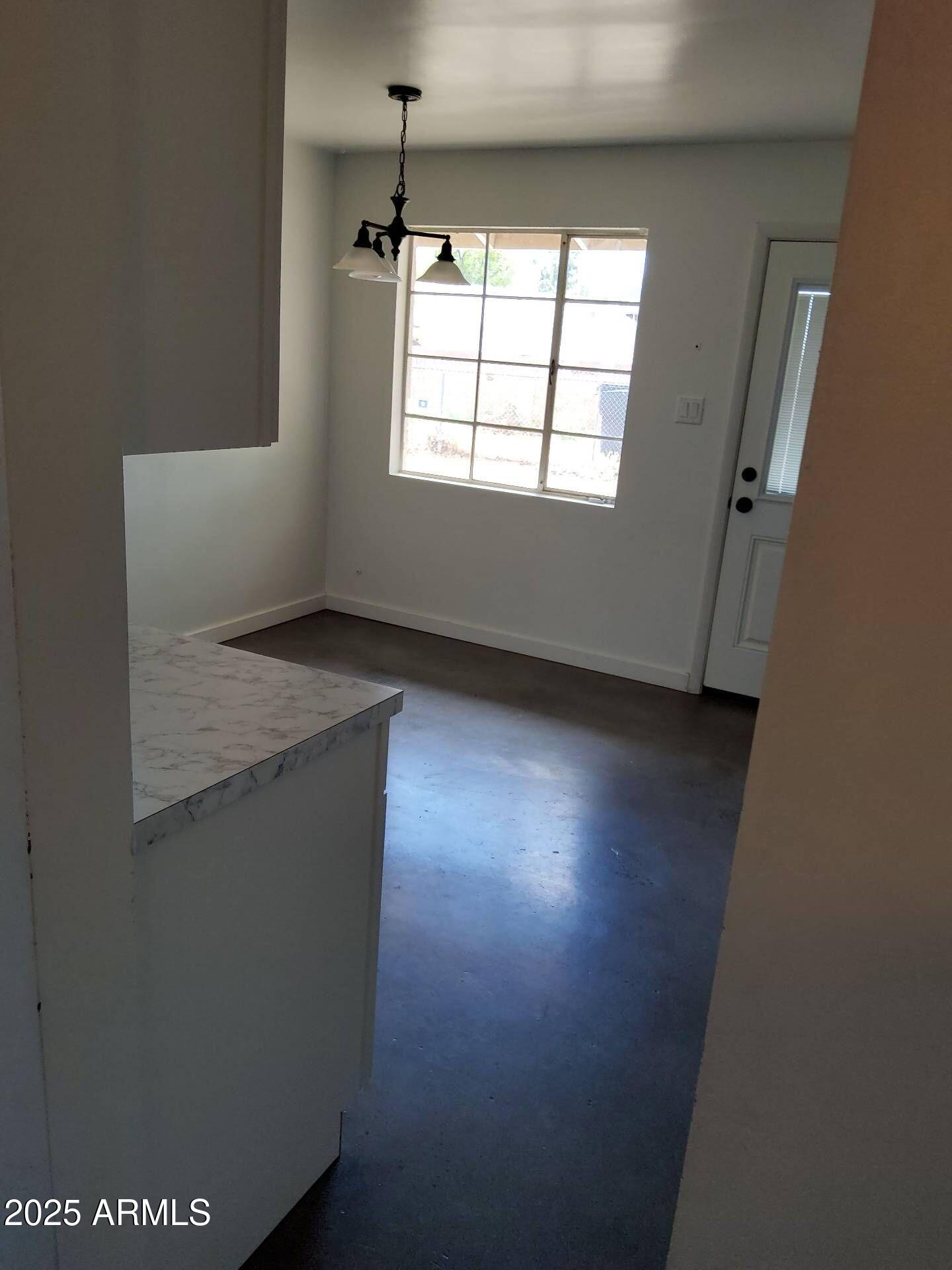 915 West 17th Place Tempe, AZ 85281 - Photo 5 of 13 an empty room with wooden floor and windows