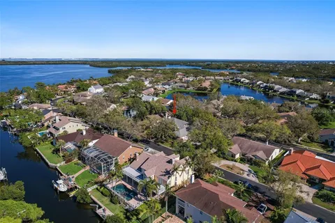 an aerial view of a city with lots of residential buildings ocean and mountain view in back