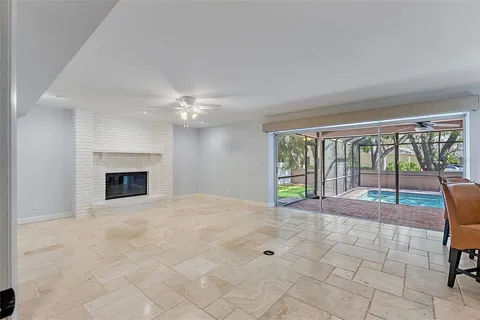 an empty room with windows and chandelier fan