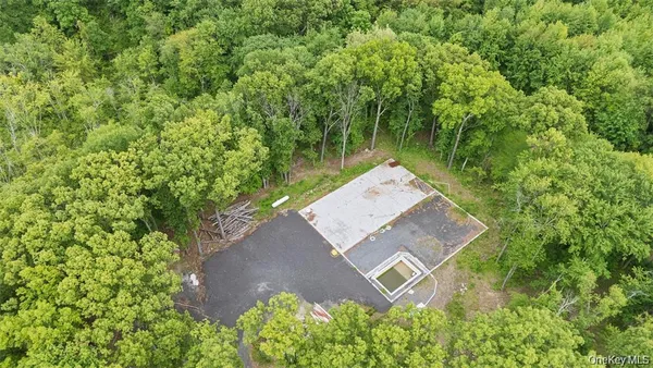 an aerial view of a house with a yard and trees all around