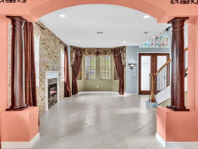 a living room with stainless steel appliances kitchen island granite countertop wooden floors and a sink